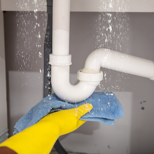 close-up of a towel being held under a leaking pipe