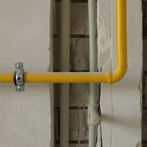 yellow gas line against a wall