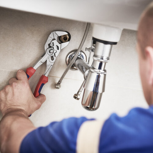 close-up of worker repairing a bathroom sink