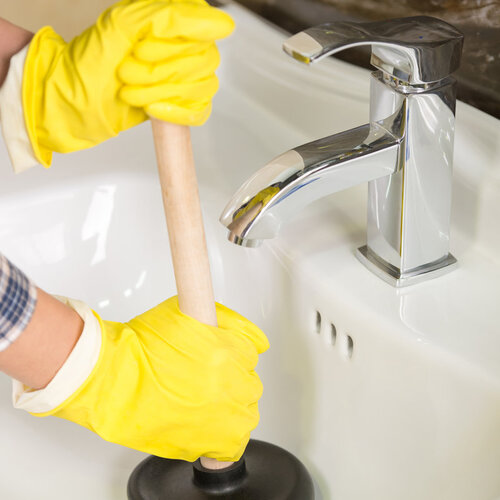 close-up of a plumber plunging a bathroom sink