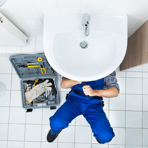 view from above of a plumber working on a sink
